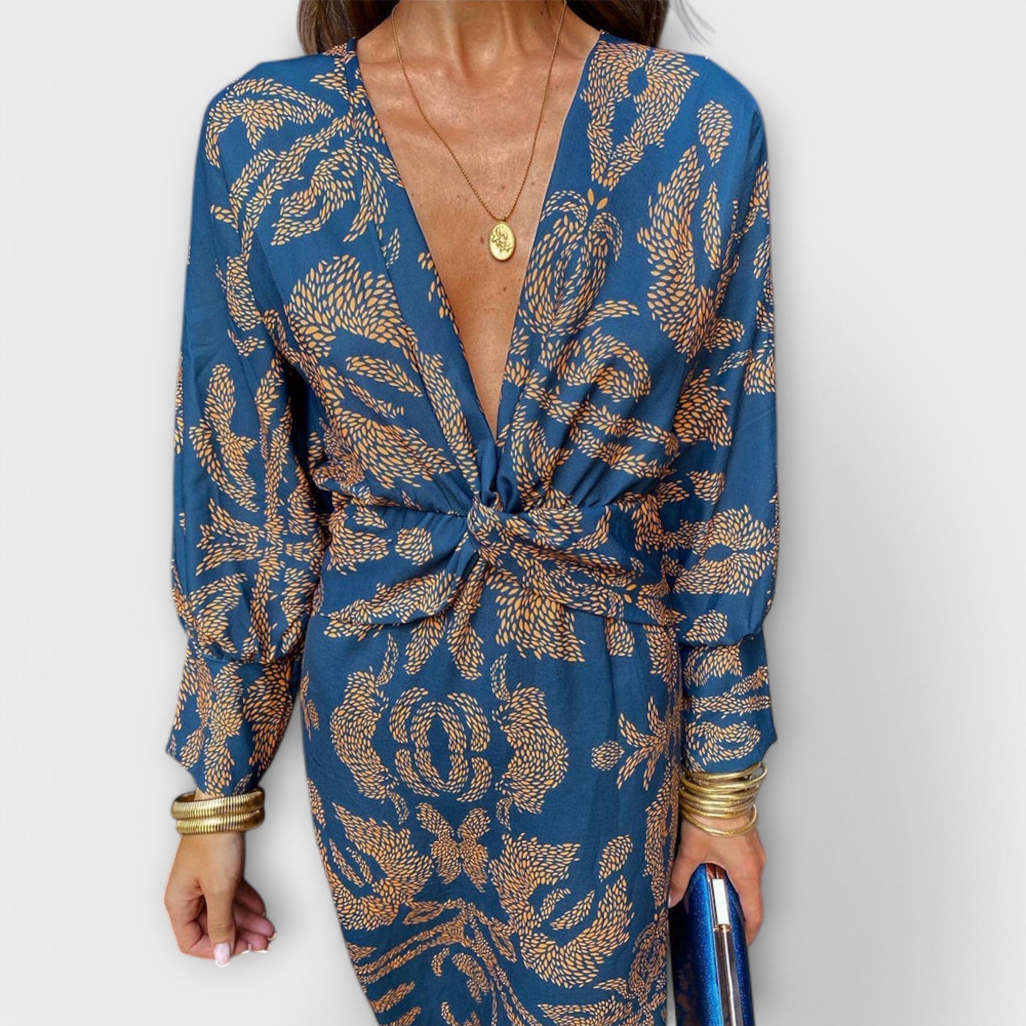 Elegant long-sleeve V-neck dress with blue and gold ornate pattern, front knot detail