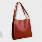 Red natural leather tote bag with short handles and minimal front tab detail