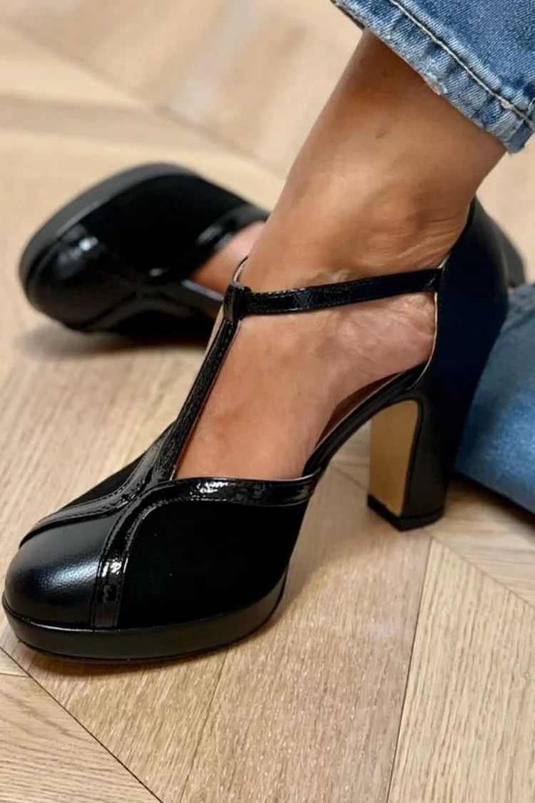 Black T-strap pumps with block heel, glossy finish, and adjustable silver buckle
