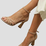 Light brown high-heel sandal with thin heel and ankle strap, open toe