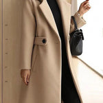 Beige winter coat with notch lapels, belt tie, and buttoned flap pockets