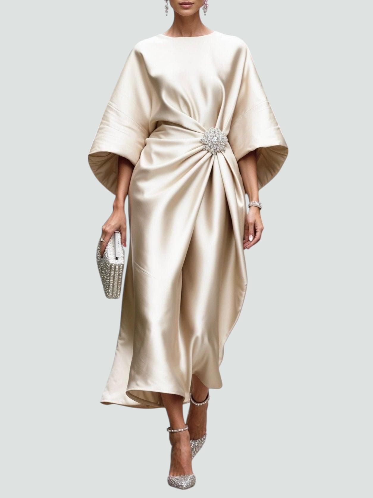Cream satin long evening dress with draped batwing sleeves and jeweled waist brooch.