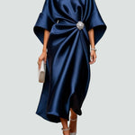Navy satin long evening dress with draped batwing sleeves and jeweled center brooch.
