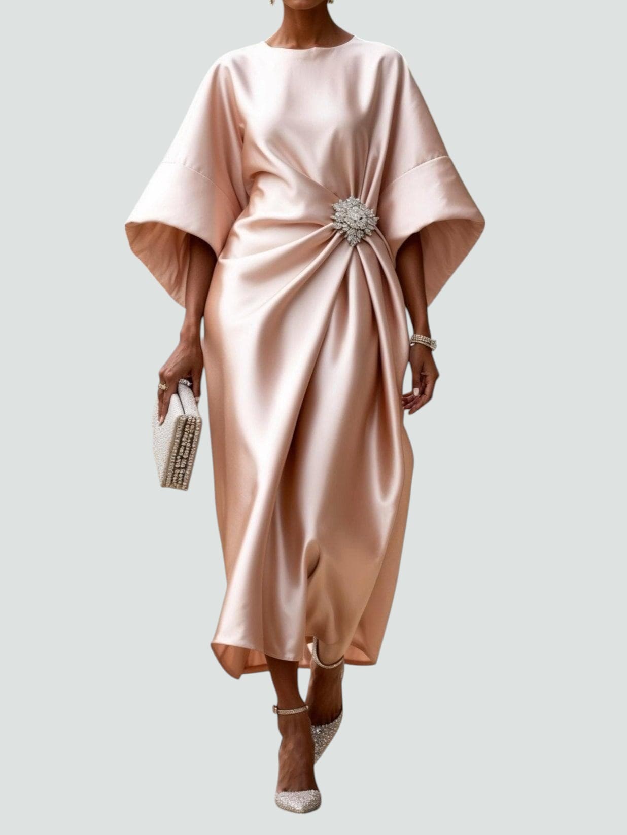 Beige satin long evening dress with draped batwing sleeves and jeweled waist brooch.