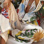 Two-piece set in cream base with multicolor print, V-neck shirt and wide-leg pants