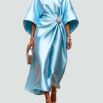 Light blue satin long evening dress with draped batwing sleeves and jeweled waist brooch.