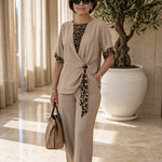 Beige two-piece pantsuit with V-neck top, leopard-print tie detail and matching pants