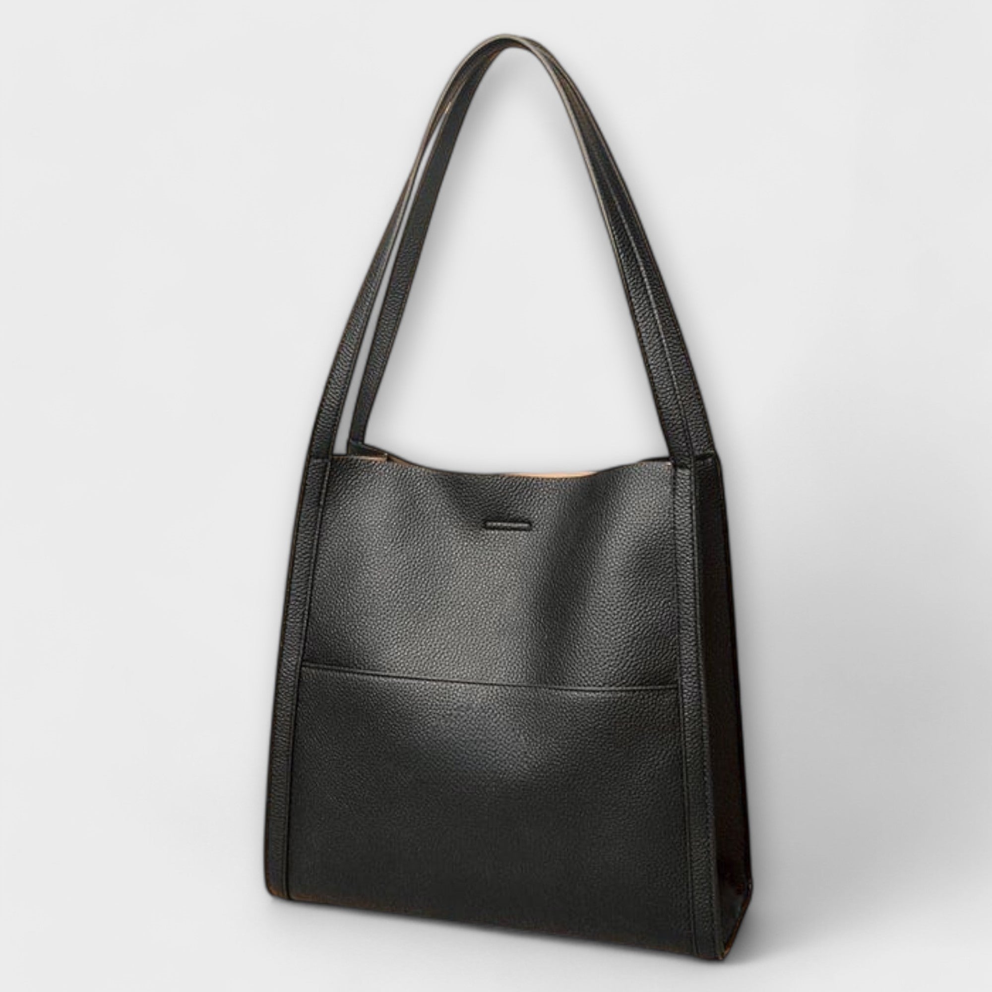 Natural leather tote bag, dark exterior, single top handles, small center clasp.