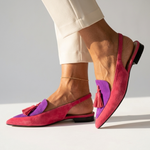Magenta pointed-toe flats with purple inserts and pink tassel detail, low heel.