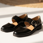 Black Mary Jane flats with open vamp and metal buckle strap, low heel