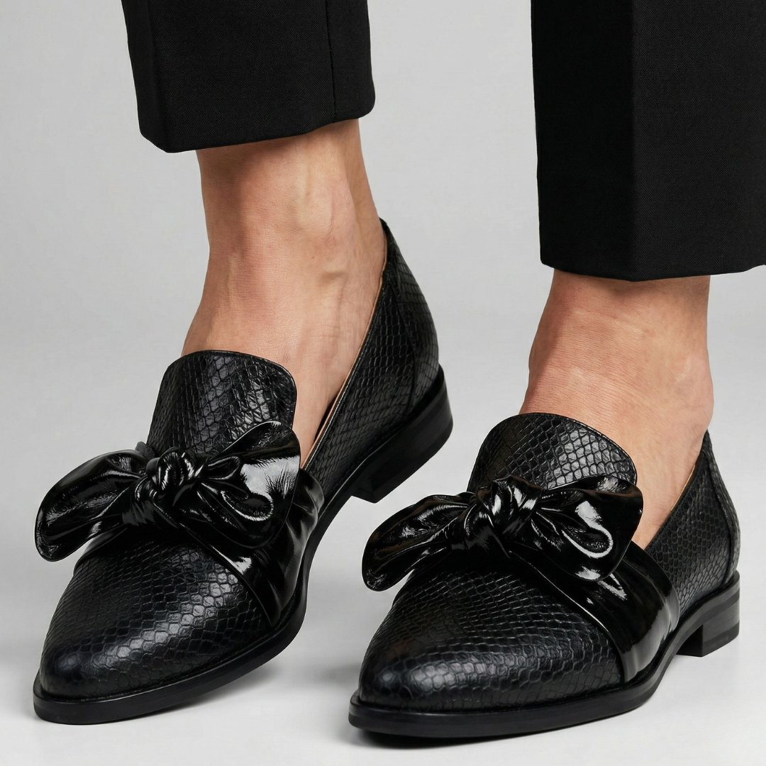 Pair of black textured loafers with glossy bow detail and low block heel