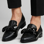 Pair of black textured loafers with glossy bow detail and low block heel