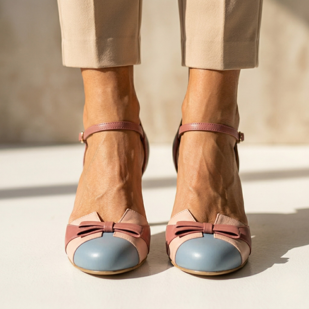 Pink leather heeled pumps with light-blue toe cap and ankle strap, bow detail