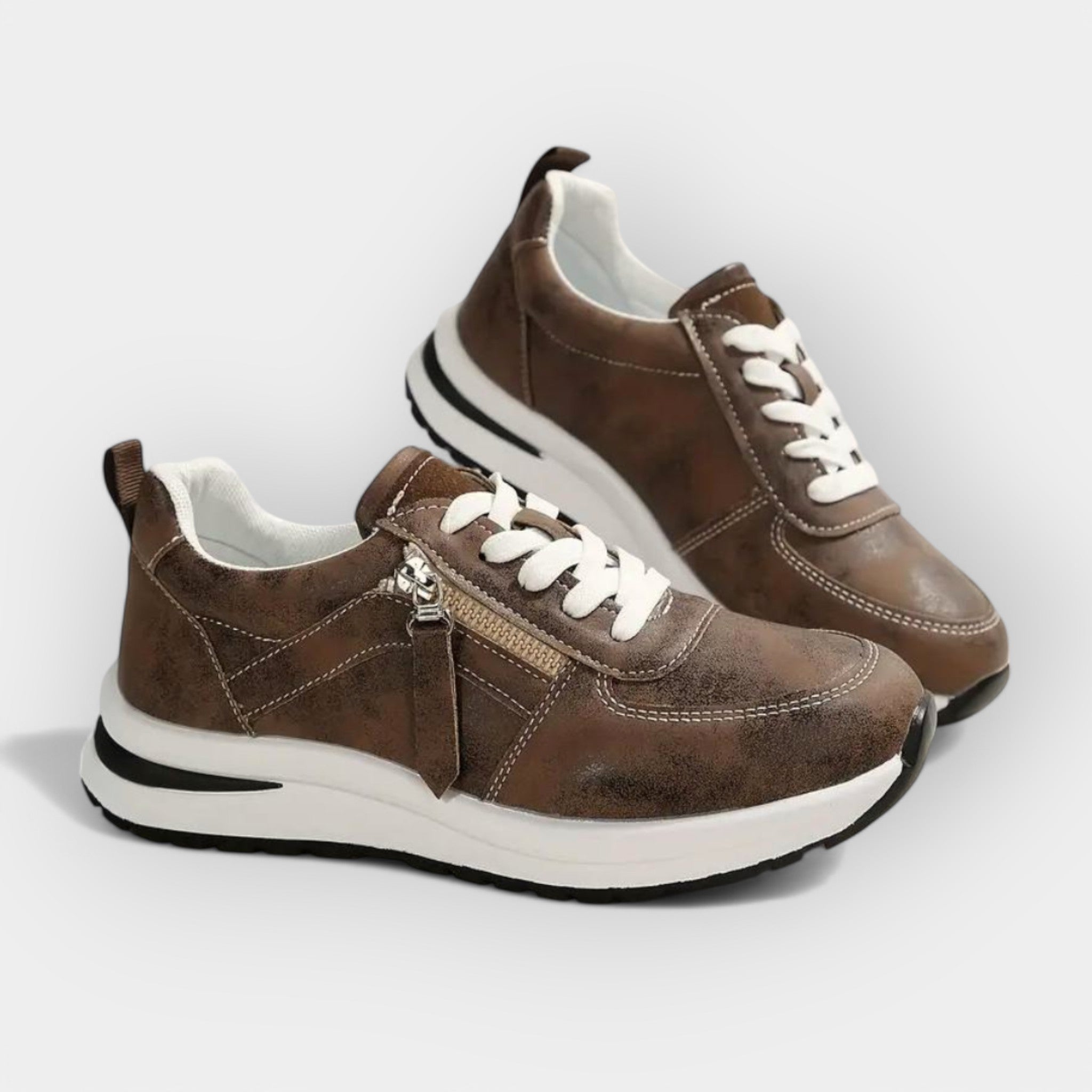Anatomical brown sneakers with white laces, side zipper, and white rubber outsole.