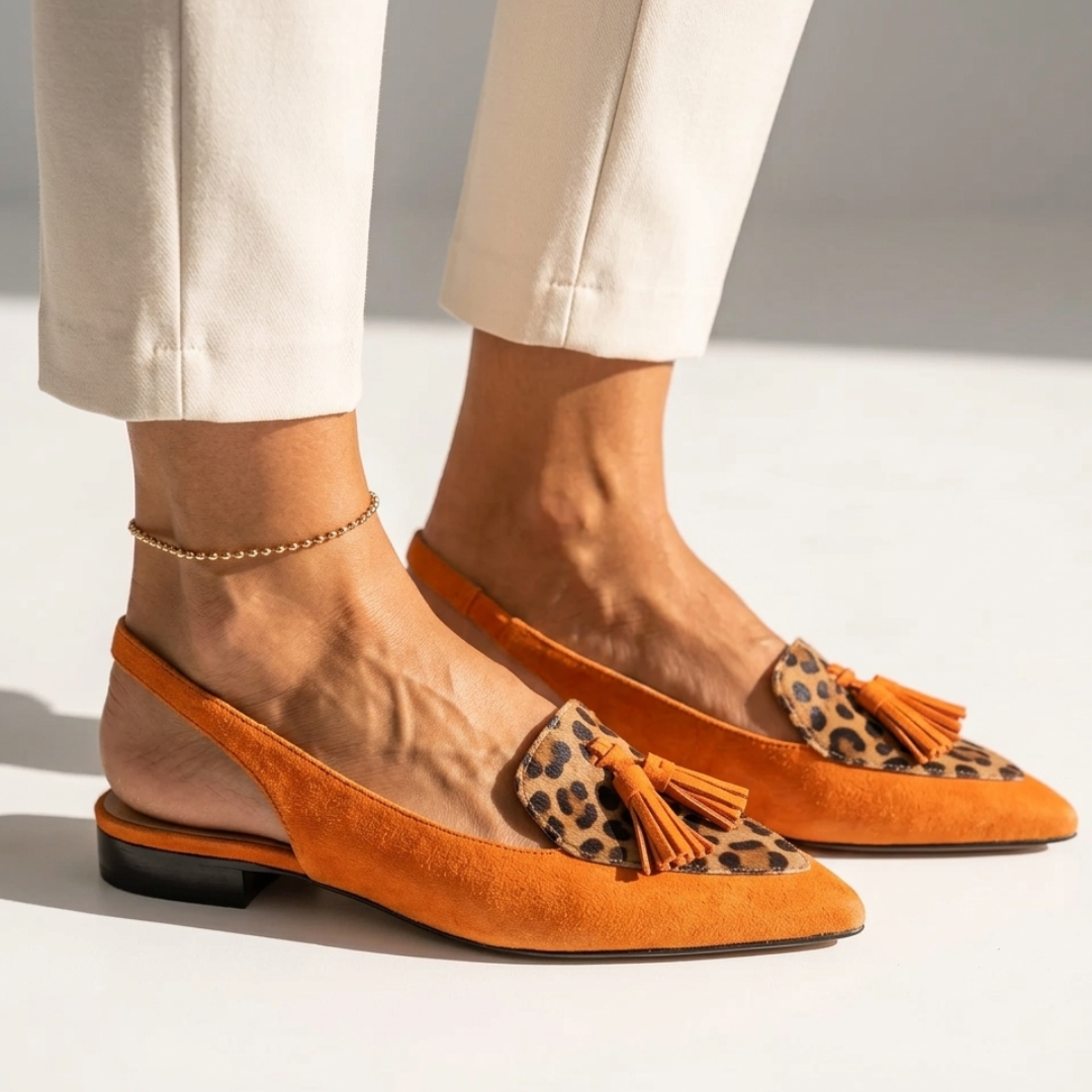 Orange pointed-toe flats with leopard-pattern inserts and orange tassels, low heel.