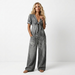 Gray denim V-neck tie-front short-sleeve jumpsuit with patch pockets and loose wide-leg fit