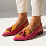 Pink pointed-toe flats with mustard-yellow inserts and pink tassel trim, low heel.