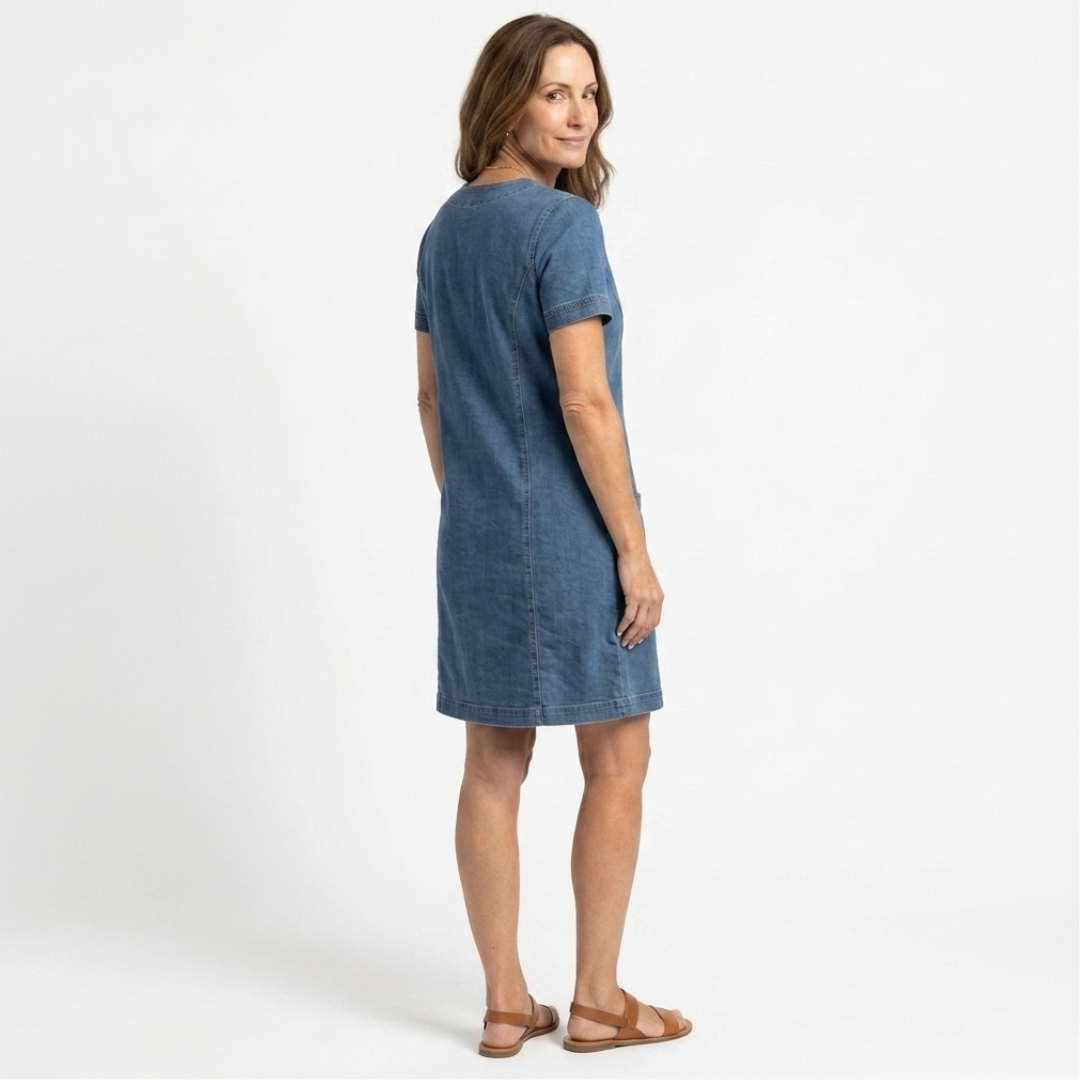 Aurora blue denim pocket dress in side view with short sleeves and fitted seams