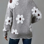 Gray knit sweater with large floral motifs on the back and ribbed hem