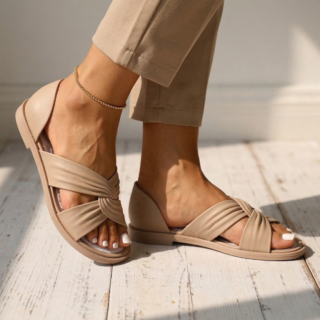 Beige orthopedic slide sandals with twisted crossover strap and ankle chain, open toe