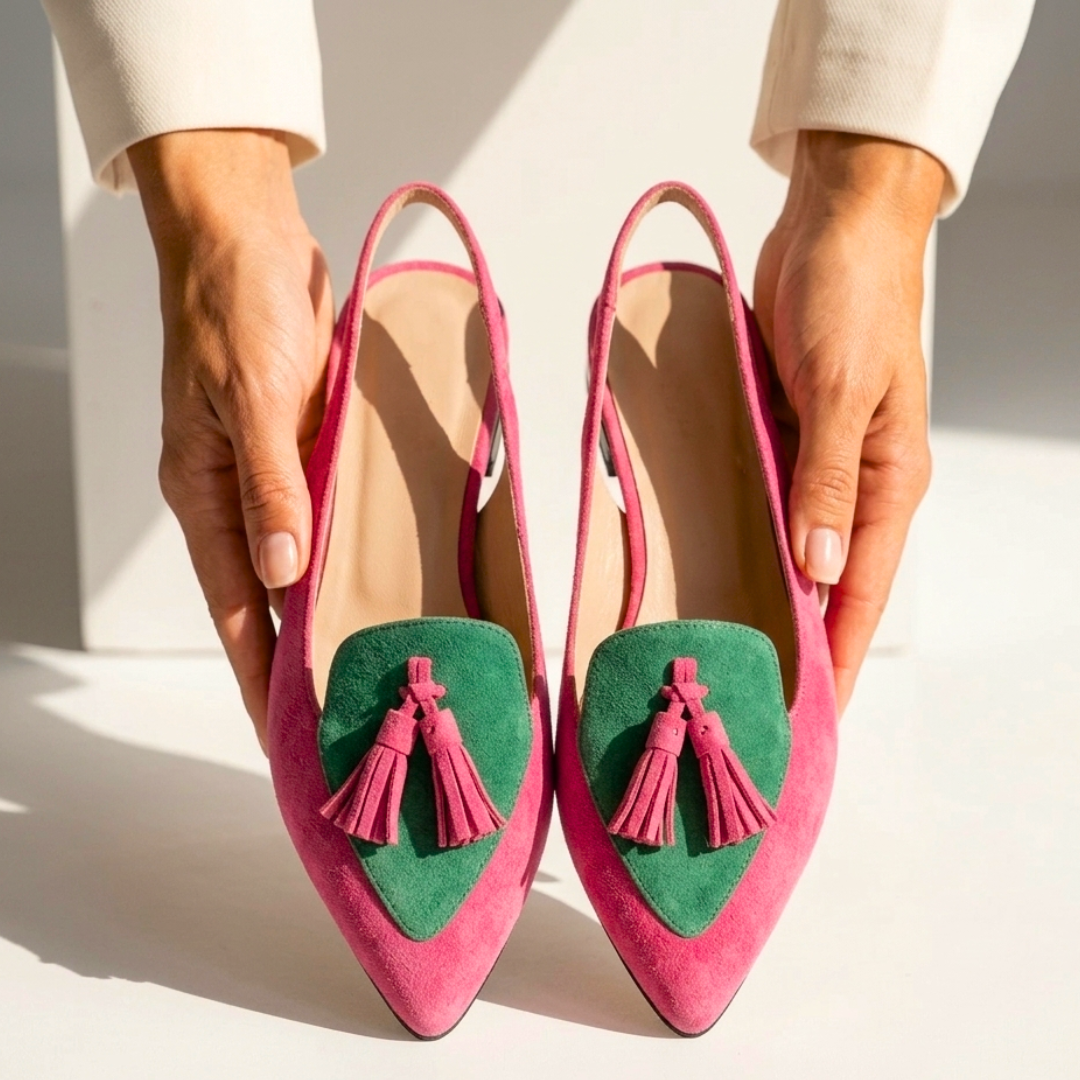 Pair of pink pointed-toe flats with green V inserts and pink tassel trim.