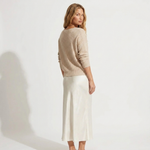 Madalina knit V-neck sweater over white satin midi dress, side view