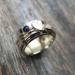 Silver heart ring with blue and white gemstones on a band