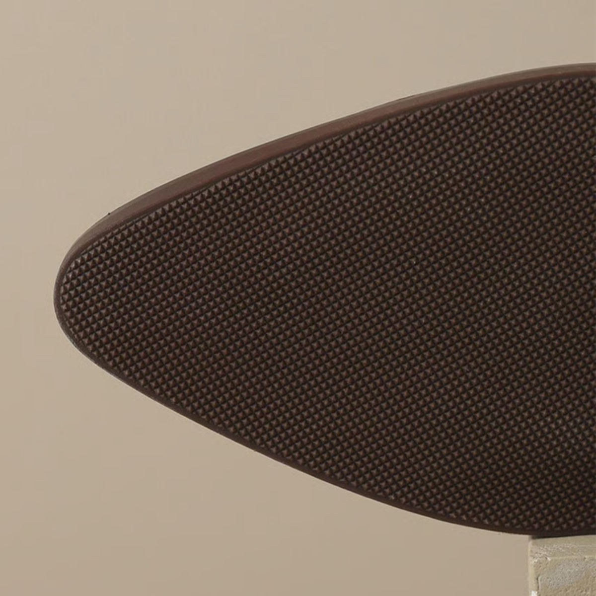 Dark brown ankle boot sole detail with textured tread and rounded toe