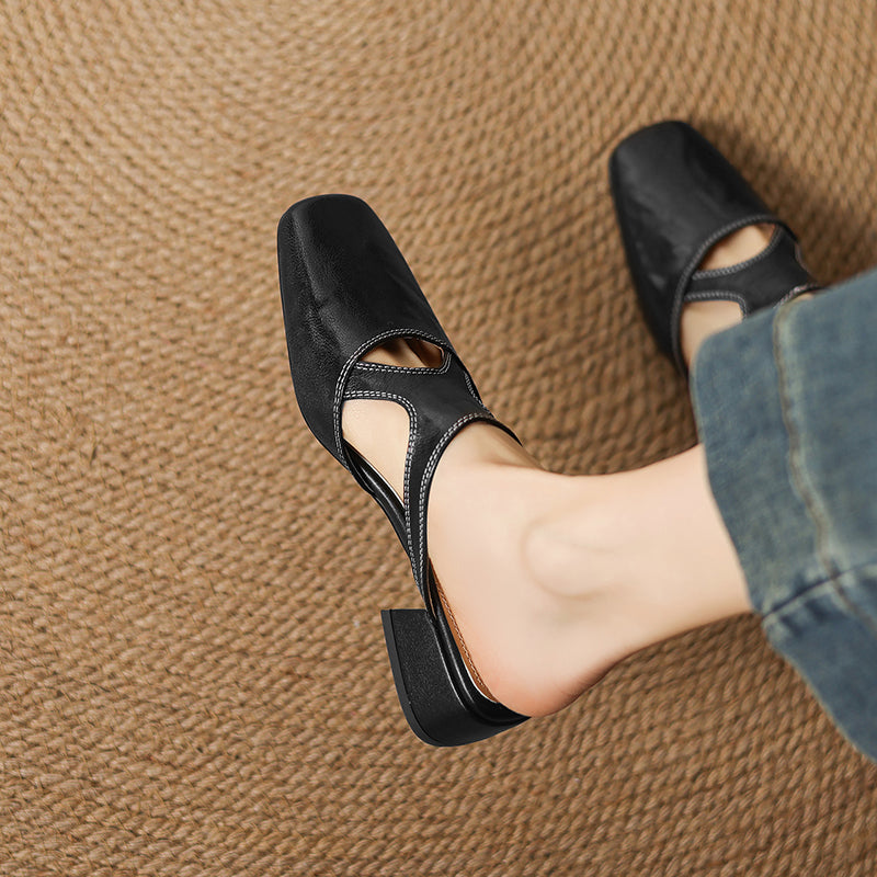 Black natural leather mule flats in profile view with low block heel and cutout strap