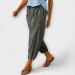 Dark gray harem pants with side pockets and button-tab cuffs, relaxed loose fit