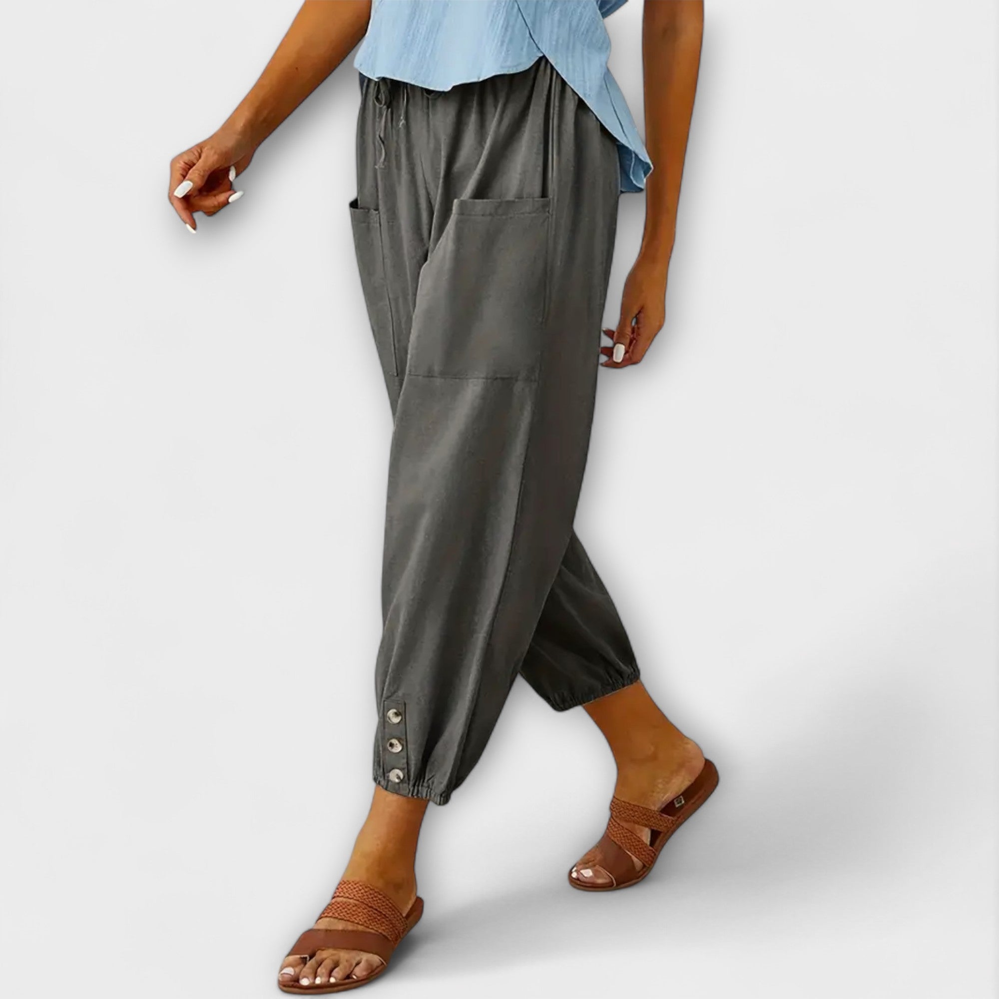 Dark gray harem pants with side pockets and button-tab cuffs, relaxed loose fit