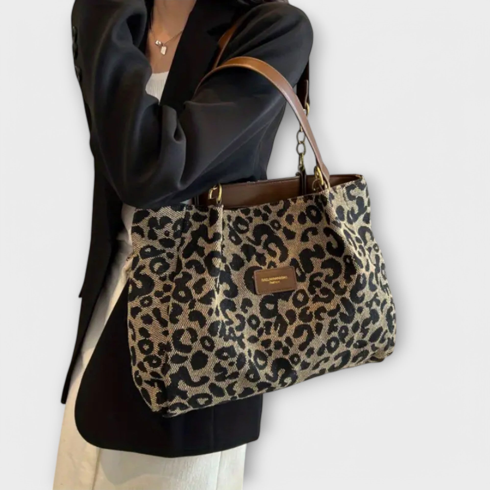 Leopard print canvas shoulder bag with brown leather trim and gold chain handles