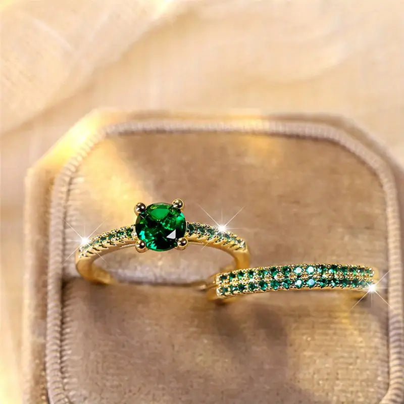 Gold-tone ring with oval emerald green gemstone and slim green pave band