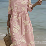 Pink midi dress with cream floral and plant embroidery, short sleeves, gathered waist.