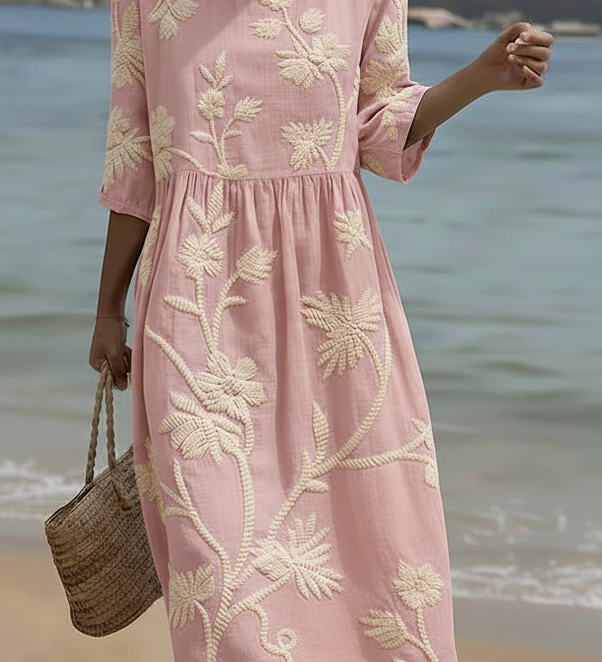 Pink midi dress with cream floral and plant embroidery, short sleeves, gathered waist.