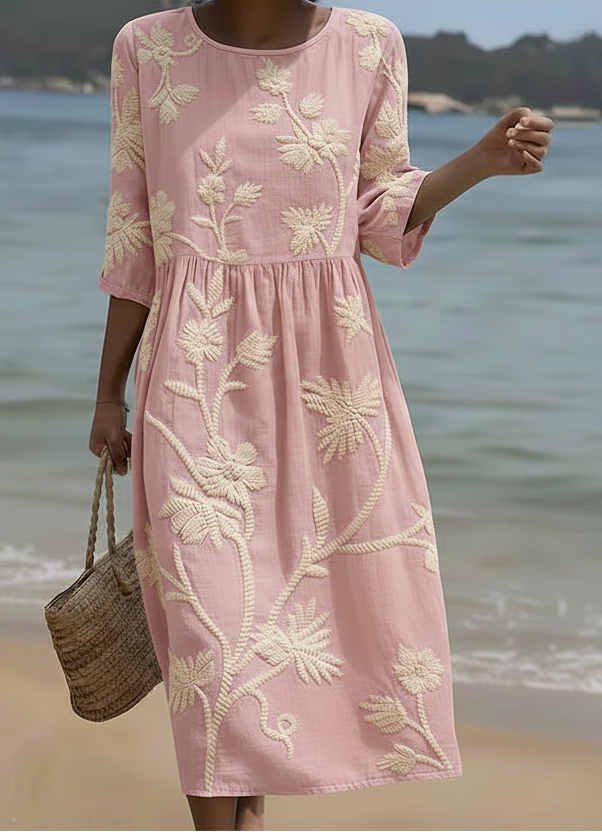 Pink midi dress with cream floral and plant embroidery, short sleeves, gathered waist.
