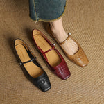 Three-color Mary Jane flats: black and red square-toe pairs with ankle straps, tan pair