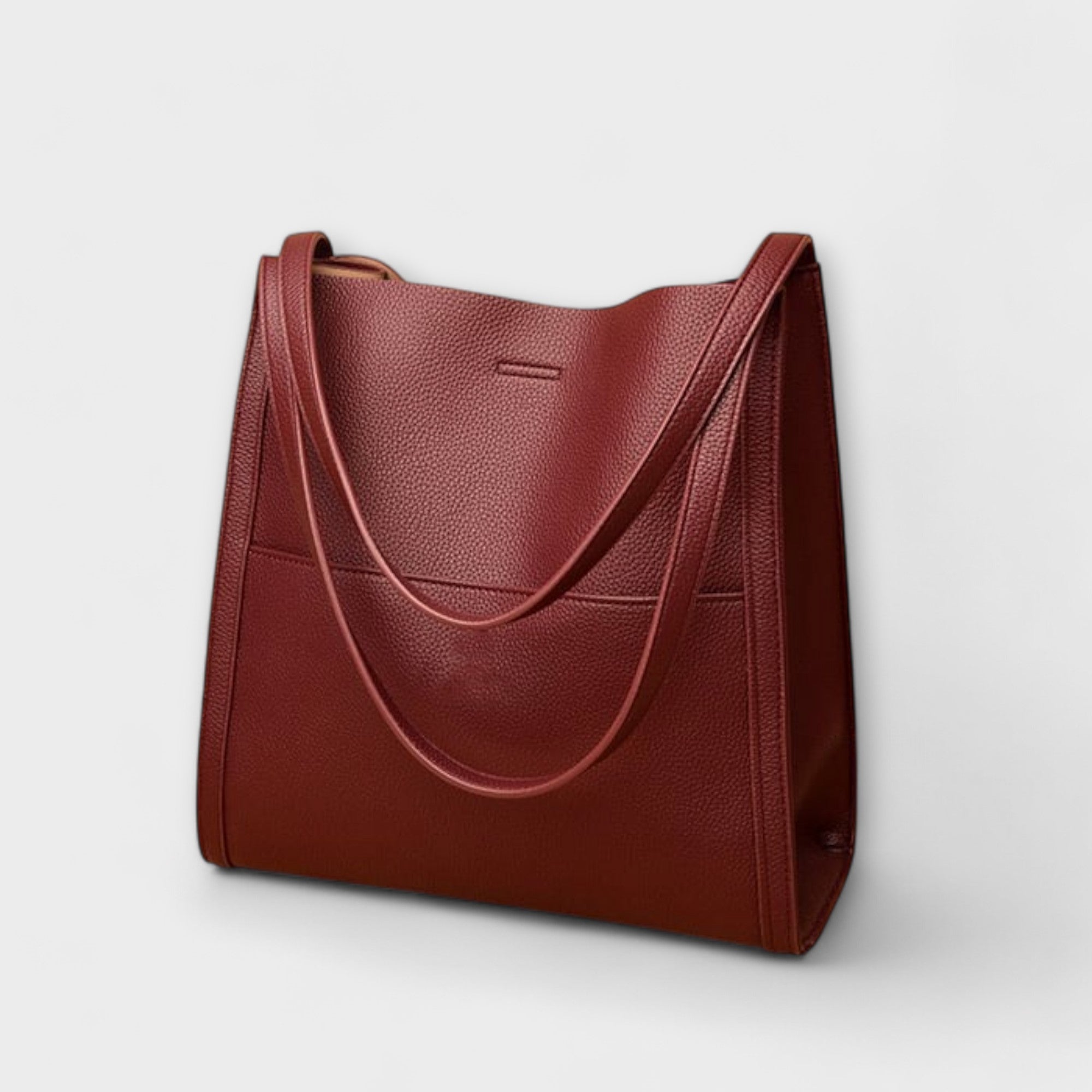 Burgundy natural leather tote bag with curved strap handles and front seam panel