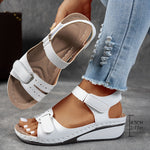 White orthopedic comfort sandals with hook-and-loop straps and cushioned wedge sole