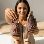 Zigzag patterned platform slide sandals with tassel straps and tan stitched sole, pair held up