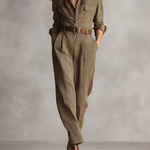Plaid collared jumpsuit with long sleeves, buttoned chest pockets, and waist belt