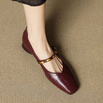 Burgundy leather ballet flats with gold buckle strap, rounded toe, and low block heel