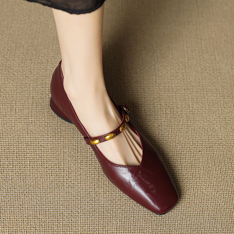 Burgundy leather ballet flats with gold buckle strap, rounded toe, and low block heel