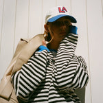Black and white striped pullover with blue trim at collar and long sleeves