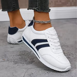 White lace-up orthopedic sneakers with navy stripe trim and low-profile chunky sole
