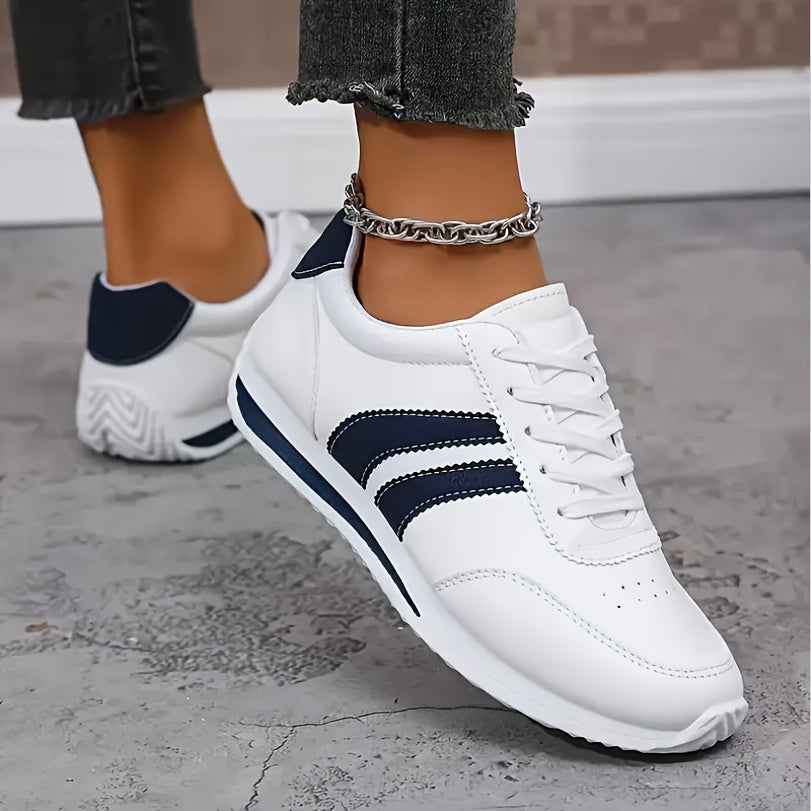 White lace-up orthopedic sneakers with navy stripe trim and low-profile chunky sole
