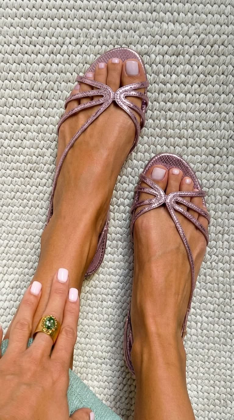 Metallic rose-gold strappy flat sandals with pink bow-style toe ornament
