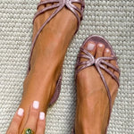 Metallic rose-gold strappy flat sandals with pink bow-style toe ornament