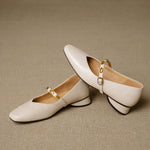 Beige leather ballet flats with gold buckled strap and short block heel