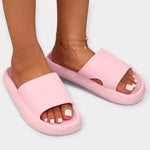 Light pink slide sandals with wide textured strap and open toe